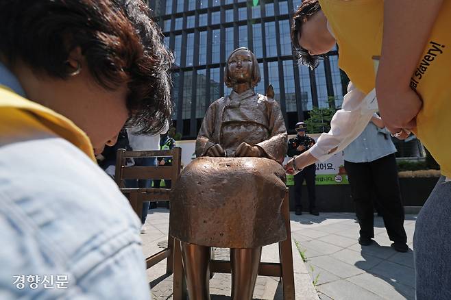 제1751차 정기 수요시위에 앞서 관계자들이 평화의 소녀상을 닦고 있다.