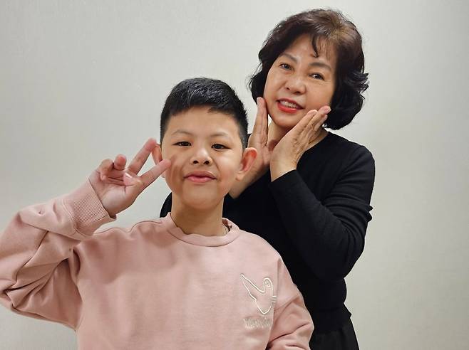 뇌사 장기기증인 고(故)천기화씨의 손주 유희찬군과 배우자노자안씨가 최근 사랑의장기기증운동본부로부터 어린이날 선물로 받은 영양제를 들고 기념촬영을 하고 있다. 사랑의장기기증운동본부 제공
