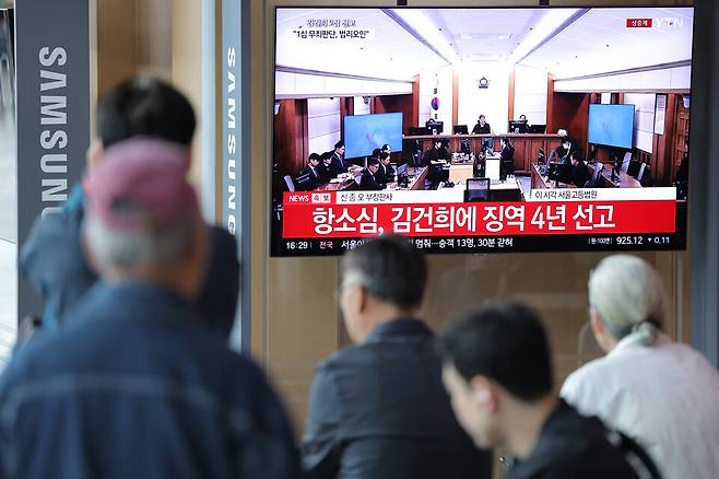 4월28일 서울역 대합실에서 시민들이 통일교 금품 수수와 도이치모터스 주가조작, 명태균 무상 여론조사 등의 혐의를 받는 김건희 여사 항소심 선고공판 생중계를 시청하고 있다. ⓒ 연합뉴스