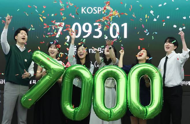 코스피가 7000을 돌파한 5월 6일 오전 서울 중구 하나은행 본점 딜링룸에서 직원들이 축하 세리모니를 하고 있다. 뉴스1