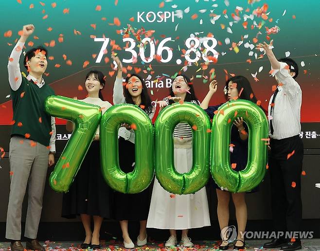 '꿈의 7천피' (서울=연합뉴스) 최재구 기자 = 코스피가 7천을 돌파한 6일 서울 중구 하나은행 본점 딜링룸에서 직원들이 축하 세리머니를 하고 있다. 2026.5.6 jjaeck9@yna.co.kr