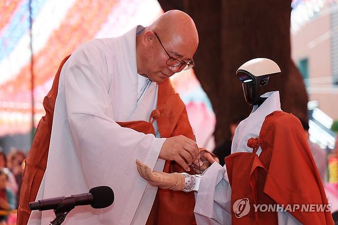 연비 받는 로봇 스님 가비 (서울=연합뉴스) 김성민 기자 = 6일 서울 종로구 조계사에서 열린 로봇 수계식에서 휴머노이드 로봇 G1 '가비'가 팔에 향불을 대어 살짝 태우는 연비를 받고 있다. 2026.5.6 ksm7976@yna.co.kr