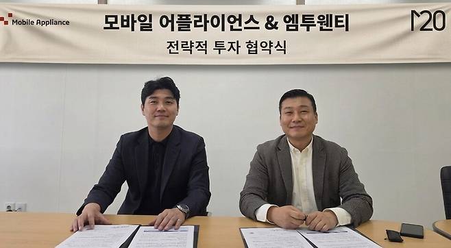 김진길 엠투웬티 대표(오른쪽)가&nbsp;'모바일어플라이언스·엠투웬티 전략적 투자 협약식'에서 박성빈 모바일어플라이언스 대표(왼쪽)와 함께 기념촬영을 하고 있다. [사진=엠투웬티]