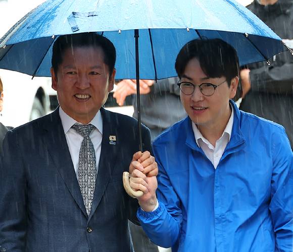 지난 3일 오후 부산 북구 구포시장에서 더불어민주당 정청래 대표와 북갑 국회의원 보궐선거 출마를 공식화한 하정우 전 청와대 AI 미래기획수석이 우산을 쓰고 이동하고 있다. [사진=연합뉴스]