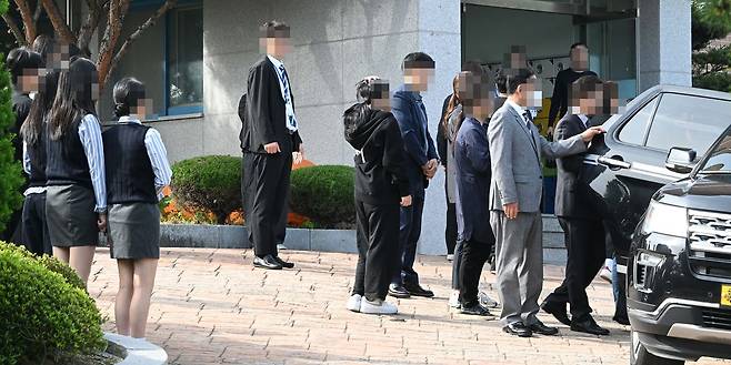 광주 도심에서 흉기 피습을 당해 숨진 고(故) A(17)양의 발인이 엄수된 7일 오전 고인의 모교인 광산구 한 고등학교에서 학교 관계자들과 학생들이 운구 차량을 향해 묵념하며 마지막 인사를 건네고 있다. 뉴시스