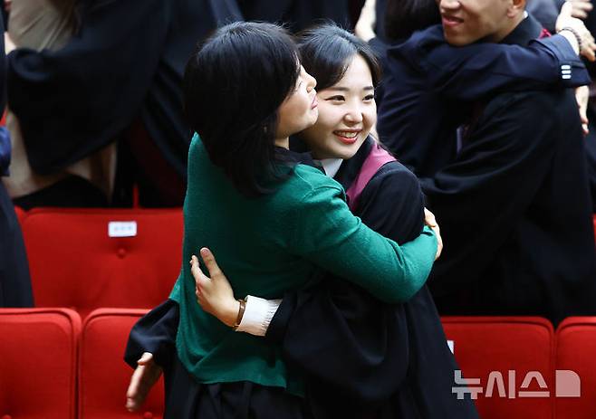 [과천=뉴시스] 황준선 기자 = 7일 오전 경기 과천시 정부과천청사 대강당에서 열린 신임 검사 임관식에서 가족들이 신임 검사에게 법복을 입혀준 뒤 포옹하고 있다. 2026.05.07. hwang@newsis.com