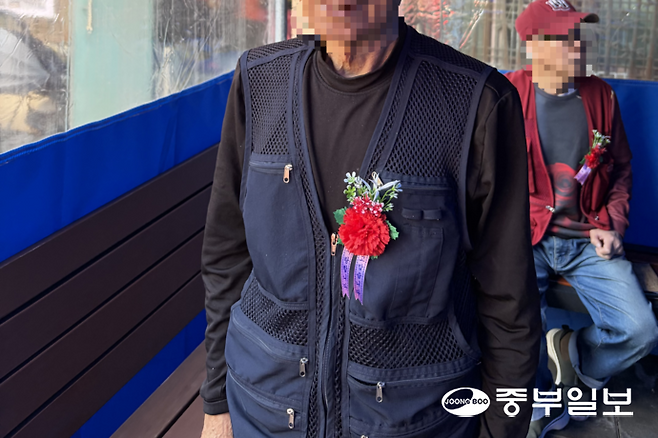 8일 오전 11시께 성남시 수정구 신흥동의 한 경로당 무료급식소에서 카네이션을 단 어르신이 식사를 기다리고 있다. 왕보빈기자