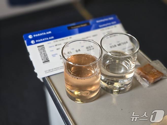 6일 인천을 출발해 도쿄로 향하는 파라타항공 A330-200 항공기 비즈니스 스마트석에서 웰컴 드링크로 파라타항공의 시그니처 음료인 '피치 온 보드'(왼쪽)와 물(오른쪽)을 약과와 함께 제공받은 모습. 피치 온 보드는 복숭아와 포도맛이 났다. 2025.5.6/뉴스1 김성식 기자