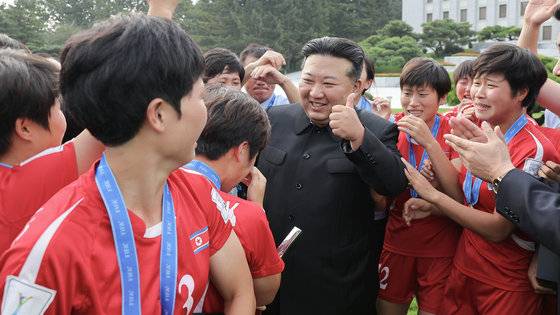 2024년 평양 중앙당 본부청사에서 콜롬비아 20세 이하(U-20) 여자 축구 월드컵 우승을 하고 돌아온 선수들에게 둘러싸인 김정은이 엄지를 들어올리며 치하하고 있다. 노동신문 뉴스1