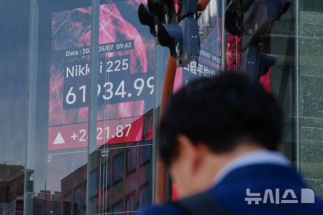 [도쿄=AP/뉴시스] 일본 도쿄의 한 증권사에서 한 시민이 닛케이지수가 표시된 주가 전광판 앞에 서 있는 모습. 2026.05.09.