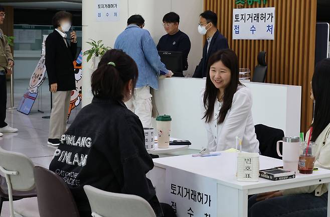 다주택자 양도소득세 중과 유예 종료일인 9일 서울 송파구청을 찾은 민원인들이 휴일 만들어진 토지거래허가 임시 접수처에서 관계 공무원과 상담하고 있다. 연합뉴스