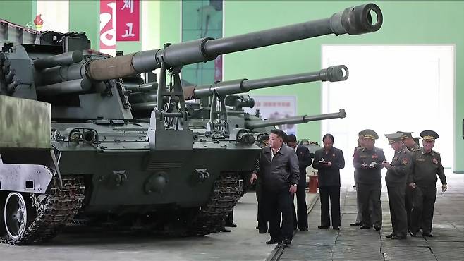 신형 155㎜ 자행평곡사포 살펴보는 김정은 김정은 북한 국무위원장(왼쪽)이 지난 6일 군 간부들과 함께 중요군수공업기업소를 찾아 ‘신형 155㎜ 자행평곡사포’를 살펴보고 있다. 조선중앙TV·뉴시스