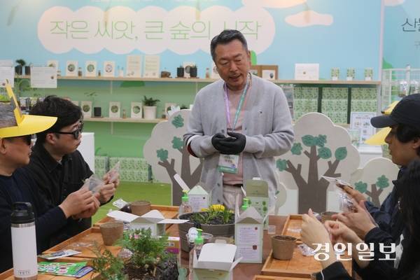 2026 고양국제꽃박람회에서 산불피해지역 복구 캠페인 부스를 운영하는 (주)틔움세상 유계림 이사가 시드볼 만들기 체험에 참여한 관람객들에게 시드볼에 대해 설명하고 있다. 고양/김도란기자 doran@kyeongin.com