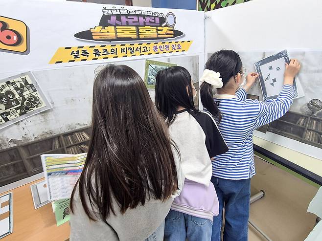 ▲&nbsp;수원동신초등학교 글향기도서관 탐정단이 암호를 해독하며 미션 수사 보고서를 완성해가고 있다. /사진제공=수원동신초등학교