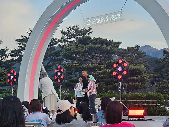 트로트 가수 장민호가 지난 9일 강원도 고성 소노델피노 리조트 야외 공연장에서 열린 '여기어때 콘서트팩 고성' 행사 무대에서 한 모녀 가족 팬과 기념사진을 찍고 있다. /고성=정재훤 기자