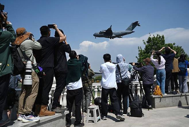 11일 중국 베이징 서우두 국제공항 인근에서 시민들이 도널드 트럼프 미국 대통령의 중국 방문 준비물을 실은 미국 공군의 C-17 수송기가 착륙하는 모습을 촬영하고 있다.AFP연합뉴스