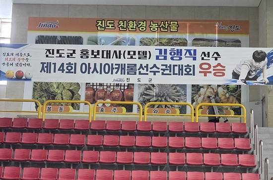 진도군청 소속이자 진도군 홍보대사인 김행직 선수의 아시아캐롬선수권 우승을 축하하는 플래카드가 진도군 실내체육관 관중석에 걸려있다. (사진=진도군당구연맹)