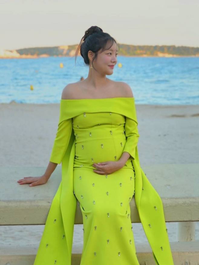 Actress Moon Ji-In shared updates on her life by releasing B-cut photos taken during her attendance at the Cannes International Series Festival in France. Through her personal channel, Moon Ji-In showcased how she perfectly pulled off a variety of styles, ranging from a black high-neck dress to a neon lime green off-shoulder dress and a white lace dress.In particular, a photo taken against a beach backdrop drew attention as she cradled her belly with her hands, clearly revealing her rhine. Moon Ji-In also displayed her cheerful charm by leaving witty replies to compliments from acquaintances.The film *Genfluencer*, starring Moon Ji-In, was invited to the Rendezvous section of the non-competition category at the 9th Cannes International Series Festival. Meanwhile, Moon Ji-In married comedian Kim Ki-ri in May 2024 and is expecting a son this coming August.