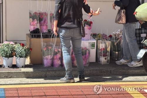 카네이션 꽃다발 가격을 묻는 손님과 응대하는 꽃집 사장 (서울=연합뉴스) 이진주 인턴기자 = 어버이 날인 지난 8일 서울의 한 꽃집에서 파는 카네이션 꽃다발. 2026.5.12