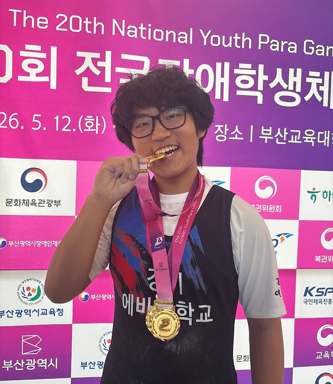 제20회 전국장애학생체육대회 역도 남자 80㎏급 파워리프트종합 지적 OPEN에서 3관왕에 오른 여시우(평택 에바다학교)가 금메달을 입에 물고 기념사진을 찍고 있다.