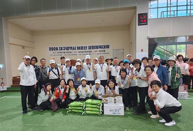 ▲ 대구 군위군이 12일 성서실내게이트볼장에서 열린 '2026 대구광역시 어르신 생활체육대회' 게이트볼 종목에서 종합우승을 한 후 기념촬영을 하고 있다. 군위군 제공