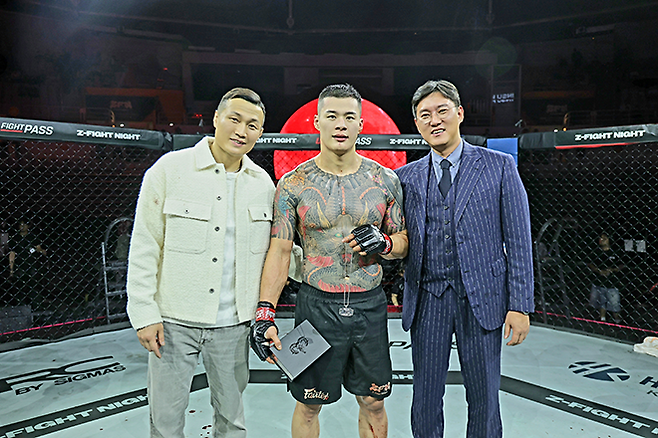 Contender Series 황인수가 2026년 5월 서울올림픽핸드볼경기장 Z-Fight Night 04 메인이벤트 승리 기념 촬영을 하고 있다. 왼쪽은 UFC 타이틀전 2회 ‘코리안 좀비’ 정찬성 ZFN 대표, 오른쪽은 새강병원 새강사랑후원회 소종근 이사장. 사진=MCP ECC