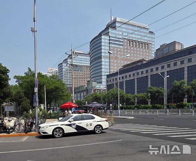 [베이징=뉴시스] 박정규 특파원 = 도널드 트럼프 미국 대통령의 방중 당일인 13일 오후 경비가 삼엄해진 가운데 미국 대표단의 숙소로 추정되는 베이징 차오양구 포시즌스호텔 주변에 공안 차량이 대기하고 있다. 2026.05.13 photo@newsis.com