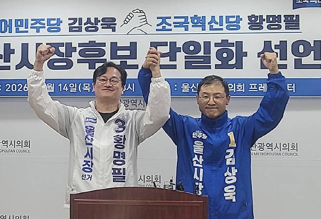 황명필 조국혁신당 울산시장 후보(오른쪽)가 14일 울산시의회 프레스센터에서 김상욱 더불어민주당 후보로의 단일화를 선언한 후 손을 잡고 인사하고 있다.(사진=연합뉴스)