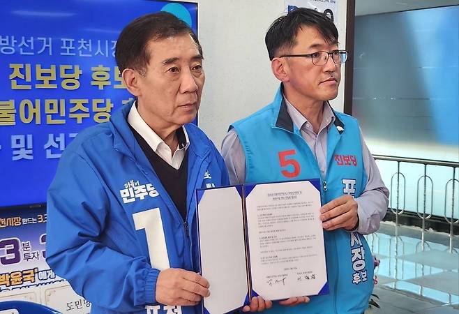 ▲ 포천시장 선거에 나선 민주당 박윤국(왼쪽) 후보와 진보당 이명원 후보가 단일화 서명식을 마친 뒤 합의문을 들어 보이고 있다. 이번 합의를 통해 박 후보는 민주개혁 진영의 단일 후보로 나서게 됐으며, 이 후보는 진보당의 핵심 공약들이 시정에 반영될 수 있도록 선거 연대를 진두지휘할 예정이다. /이광덕 기자 kdlee@incheonilbo.com