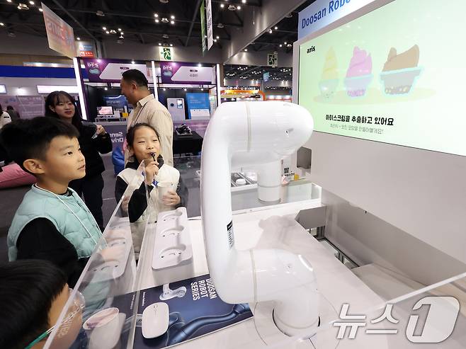 지난 2025년 11월5일 경기 고양시 일산서구 킨텍스에서 열린 '2025 디지털퓨처쇼'에서 ‘두산로보틱스’의 아이스크림 로봇 ‘아리스’가 관람객에게 아이스크림을 건네고 있다. 2025.11.5 ⓒ 뉴스1 황기선 기자