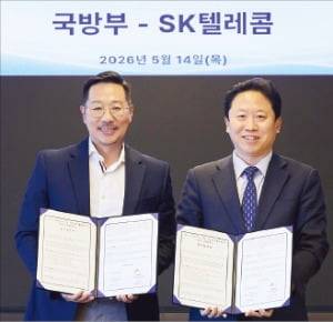 14일 SKT타워에서 열린 ‘독자 AI 파운데이션 모델 국방 분야 활용’ 업무협약(MOU)에서 김명국 SK텔레콤 본부장(왼쪽)과 전준범 국방부 국방인공지능기획국장이 사진을 촬영하고 있다. /SK텔레콤 제공