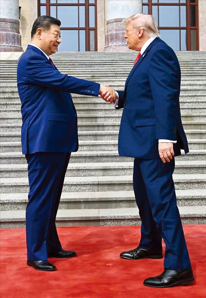 < 시진핑 키 맞춰준 트럼프 > 도널드 트럼프 미국 대통령과 시진핑 중국 국가주석 간 정상회담이 14일 중국 베이징에서 시작됐다. 트럼프 대통령이 인민대회당 앞에서 시 주석과 악수하며 다리를 벌려 키를 맞춰주는 듯한 모습을 연출했다. 두 정상의 키 차이는 10㎝ 정도다.  /AFP연합뉴스
