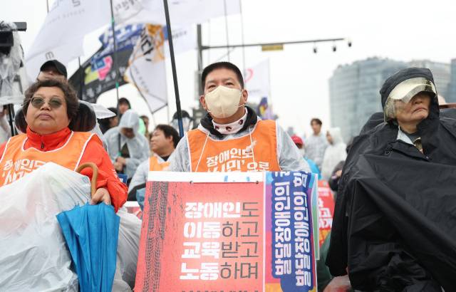 ▲전국장애인차별철폐연대 등 207개 단체로 구성된 '4.20 장애인차별철폐 공동투쟁단'이 장애인의 날인 4월 20일 서울 종로구 광화문 서십자각 인근에서 연 결의대회에서 참가자들이 피켓을 들고 있다. ⓒ연합뉴스