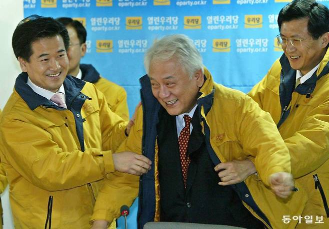 2004년 1월 24일 열린우리당 정동영 의장(왼쪽)이 확대간부회의후 공천확정자인 김한길 후보에게  공천장을 준뒤 당의 상징색으로 정한 노란 점퍼를 입혀주고있다2004년 1월 24일. 서영수 기자. 동아일보 DB.