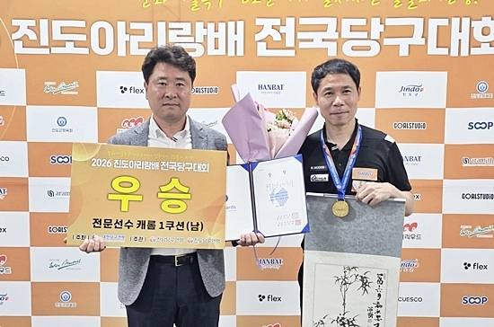 허정한이 15일 전남 진도군 실내체육관에서 열린 ‘2026 진도아리랑배 전국3쿠션대회’ 남자1쿠션 결승전에서 차명종을 꺾고 우승을 차지했다. 허정한(오른쪽)이 시상식서 진도당구연맹 김연일 회장과 포즈를 취하고 있다. (사진=대한당구연맹)