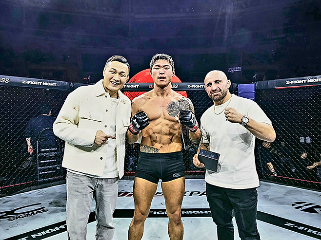 초대 블랙컴뱃 웰터급 챔피언 최준서가 2026년 5월 서울올림픽핸드볼경기장 Z-Fight Night 04 승리 기념 촬영을 하고 있다. 왼쪽은 UFC 페더급 타이틀 도전자 ‘코리안 좀비’ 정찬성 ZFN 대표, 오른쪽은 제5·7대 UFC 페더급 챔피언 알렉산더 볼카노프스키. 사진=MCP ECC