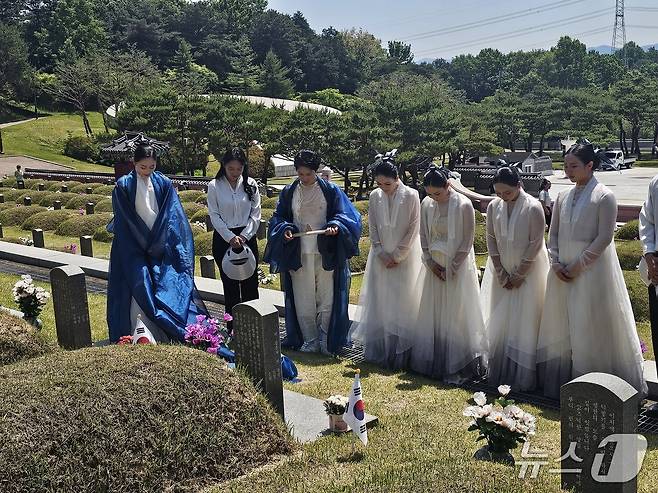 17일 제46주년 5·18민주화운동 추모식에서 추모 공연을 마친 김연우 씨와 동료들이 국립 5·18민주묘역에 안장돼 있는 연우 씨의 아버지 고 김영철 시민군 기획실장 묘비에 묵념을 올리고 있다. 2026.5.17/뉴스1 최성국 기자