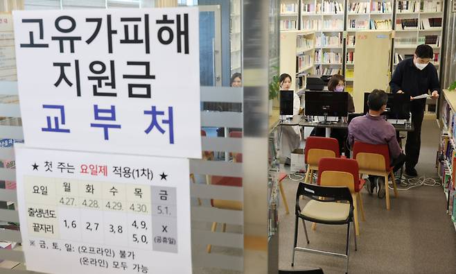고유가 피해지원금 1차 지급 첫날인 지난달 27일 부산 부산진구 가야2동 주민센터에서 주민들이 지원금을 신청하고 있다. [연합뉴스]