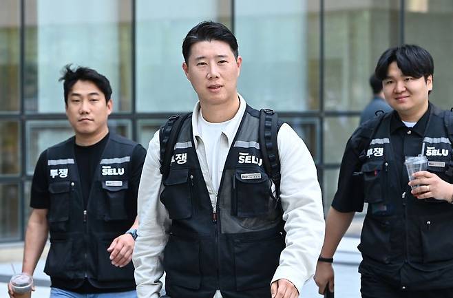 최승호 초기업노조 삼성전자지부 위원장(가운데)이 지난 13일 경기 수원시 영통구 수원지방법원에서 열린 삼성전자 노조 위법 쟁의행위 금지 가처분 신청 2차 심문을 마친 뒤 법원을 나서고 있다. 뉴시스