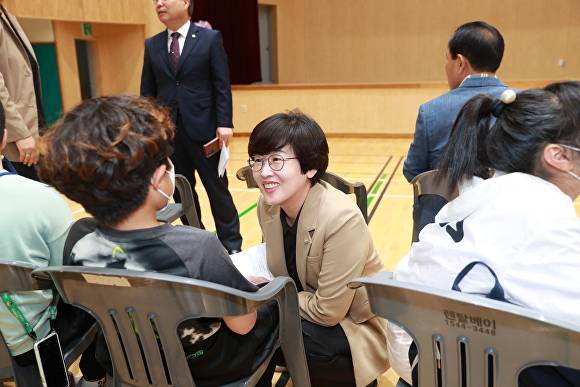 지민 후보가 어린이와 무릎을 맞추고 앉아 환한 미소로 대화를 나누고 있다. [사진=지민 캠프]