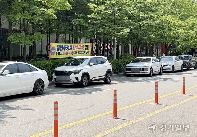 17일 오전 인천 연수구 송도 트리플스트리트 인근 불법 주정차 단속 현수막이 붙어 있지만 차량들이 길게 늘어서 있다. 김샛별기자