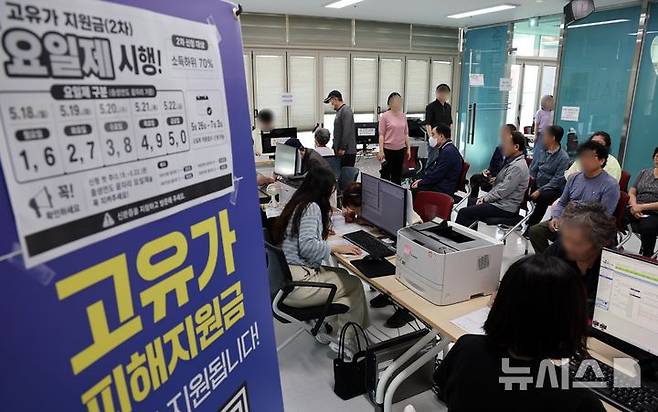 [부산=뉴시스] 하경민 기자 = 정부 고유가 피해지원금 2차 신청·지급 첫날인 18일 부산 부산진구 개금3동행정복지센터에서 주민들이 선불카드형 지원금을 받고 있다. 2026.05.18. yulnetphoto@newsis.com