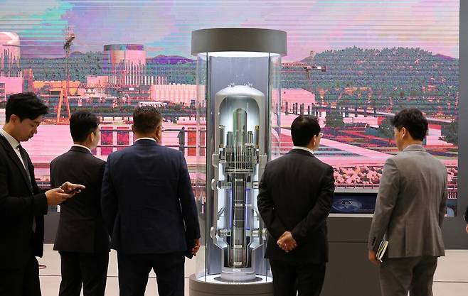 '2026 부산국제원자력산업전' 관람객들이 지난달 22일 부산 해운대구 벡스코 제1전시장에서 혁신형 소형모듈원전(I-SMR) 모형을 살펴보고 있다. [사진=연합]