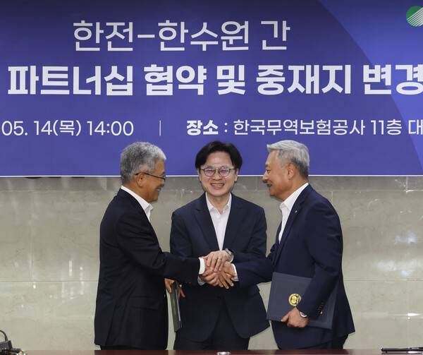 14일 중구 무역보험공사에서 열린 '한전-한수원 간 원전수출 전략적 파트너십 협약 및 중재지 변경 협약 체결식'에서 김정관 산업통상부 장관(가운데)이 협약서에 서명한 김동철 한국전력 사장(왼쪽), 김회천 한국수력원자력 사장(오른쪽)과 악수하고 있다. 2026.5.14. 연합뉴스
