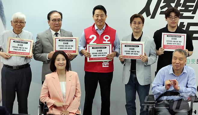 오세훈 국민의힘 서울시장 후보가 19일 오전 서울시 종로구 선거 캠프에서 열린 서울시 장애인단체 관계자들과의 간담회를 마친 뒤 정책 제안서를 들고 기념 촬영을 하고 있다. 2026.5.19 ⓒ 뉴스1 김진환 기자