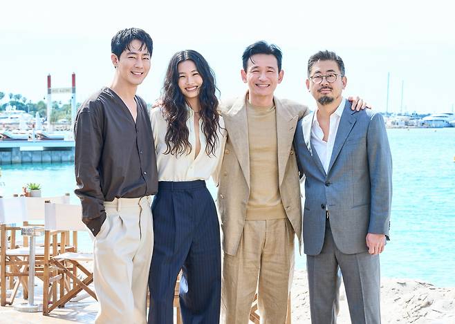 제79회 칸 국제영화제 경쟁 부문에 초청된 영화 <호프>의 주연배우 조인성, 정호연, 황정민과 나홍진 감독이 프랑스 칸 팔레 드 페스티발 인근 해변에서 기념 사진을 찍고 있다. 플러스엠 엔터테인먼트 제공