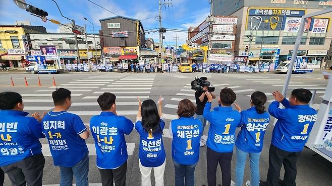▲ 21일 오후 덕정역 광장에서 열린 더불어민주당 정덕영 양주시장 후보 출정식에서 정덕영(오른쪽) 후보가 소속 시·도의원 후보 전원과 함께 지지를 호소하고 있다. 정 후보는 지체된 광역 교통망 확충 사업의 행정 절차를 조기 단축해 시민 출퇴근 불편을 종식하겠다고 공언했다. /이광덕 기자 kdlee@incheonilbo.com