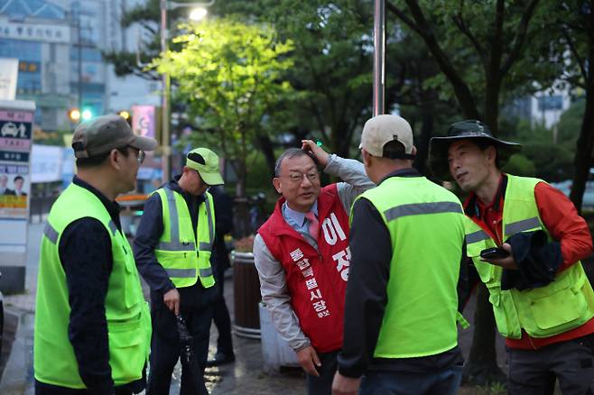 6·3 지방선거 공식 선거운동 첫날인 21일 오전 5시, 국민의힘 이정현 전남광주통합특별시장 후보가 광주 북구청 민방위 훈련장에서 형광 조끼를 입은 환경미화원들과 악수하며 아침 인사를 나누고 있다. /김성빈 기자 ksb@namdonews.com