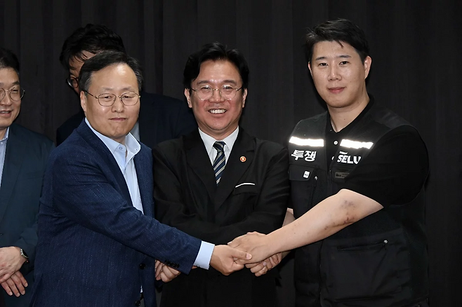(왼쪽부터) 여명구 삼성전자 DS(디바이스솔루션·반도체 사업 담당) 피플팀장과 김영훈 고용노동부 장관, 최승호 삼성그룹 초기업노동조합 삼성전자지부 위원장이 지난 20일 경기도 수원시 장안구 경기고용노동청에서 열린 삼성전자 임금협상을 마친 후 잠정 합의한에 서명하고 손을 맞잡고 있다.