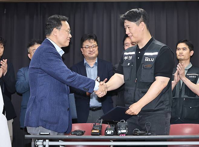 20일 경기 수원시 장안구 경기고용노동청에서 열린 삼성전자 임금협상을 마친 후 여명구 삼성전자 DS(디바이스솔루션·반도체 사업 담당) 피플팀장과 최승호 삼성그룹 초기업노동조합 삼성전자지부 위원장이 악수를 하고 있다./뉴스1